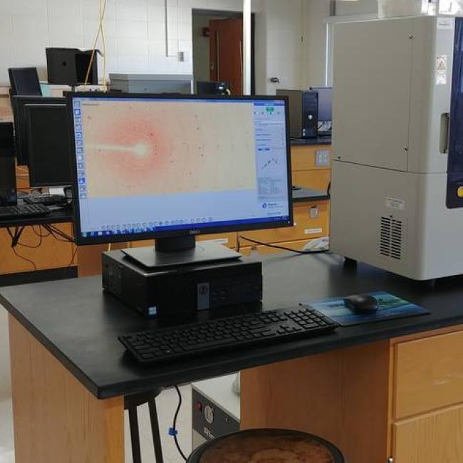 An X-ray diffractometer machine with a desktop computer screen