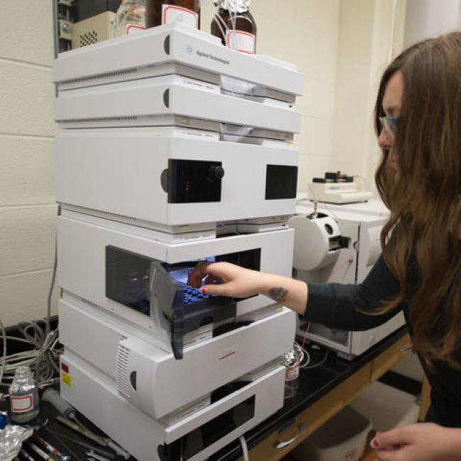 Student using piece of chemistry equipment called Agilent 6120 LC