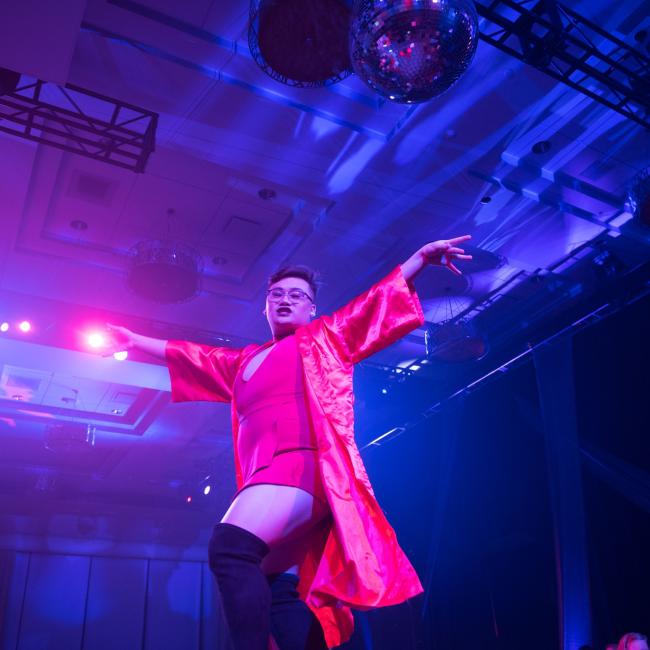 A performer on stage with fancy pink costume at the Fire ball, UWEC drag ball extravaganza event