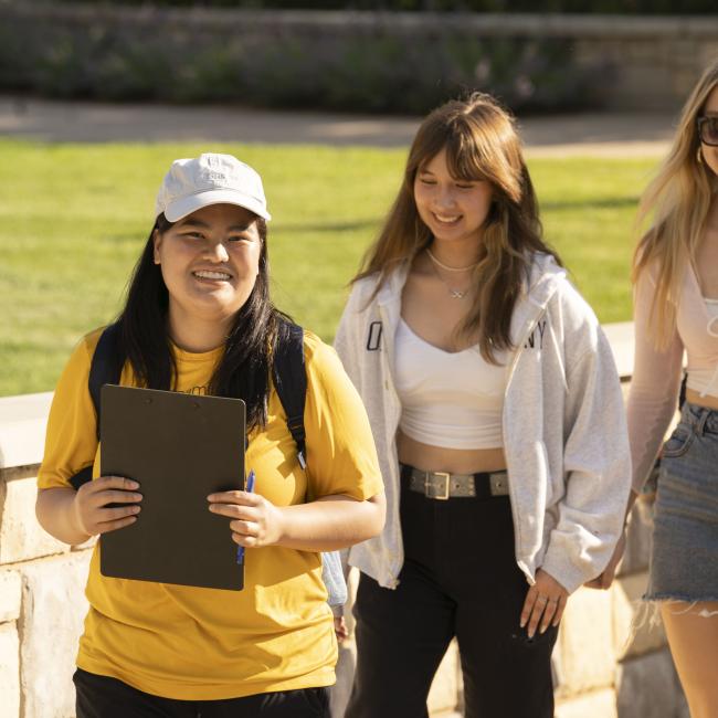 Students with orientation guide walking and smiling 