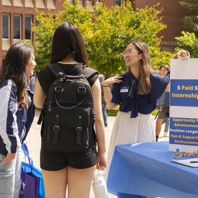 Students talking with an employer at the fall part-time job fair.