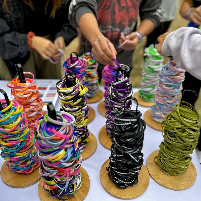 A bunch of colorful silicone bracelets representing a diverse array of queer identities.