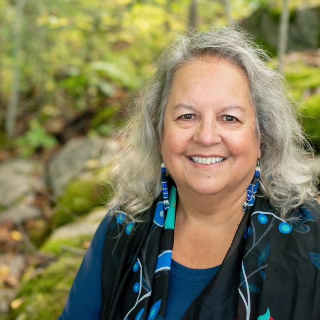 A woman smiles facing the camera.