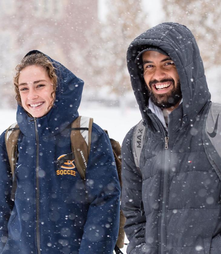 Two students walking in the snow