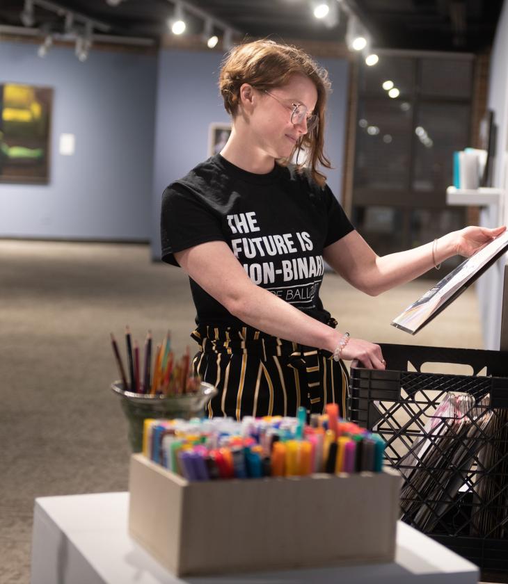 student setting up exhibit in Foster Gallery