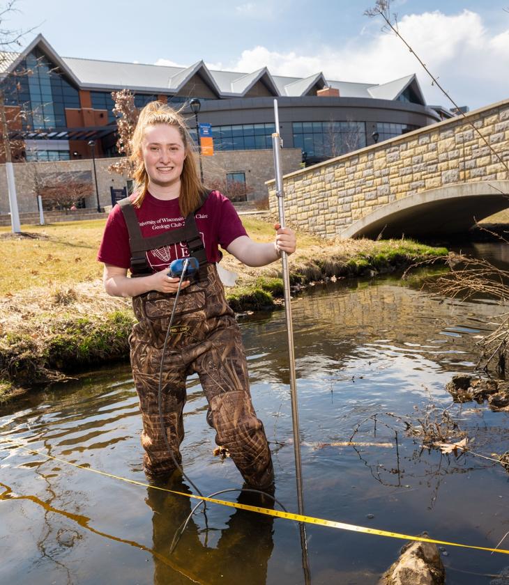 female student in creek on campus