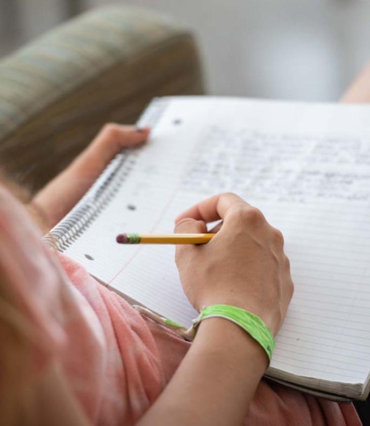 student writing in a notebook