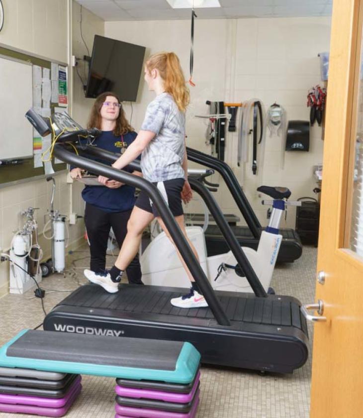 Exercise science lab, girl on treadmill with observer 