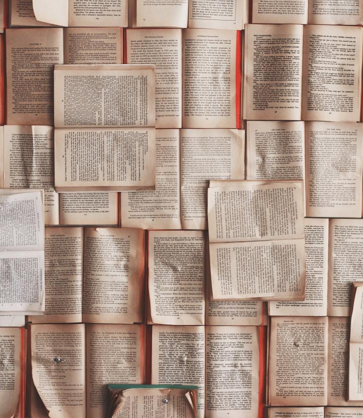 Books laying flat open in a pile 