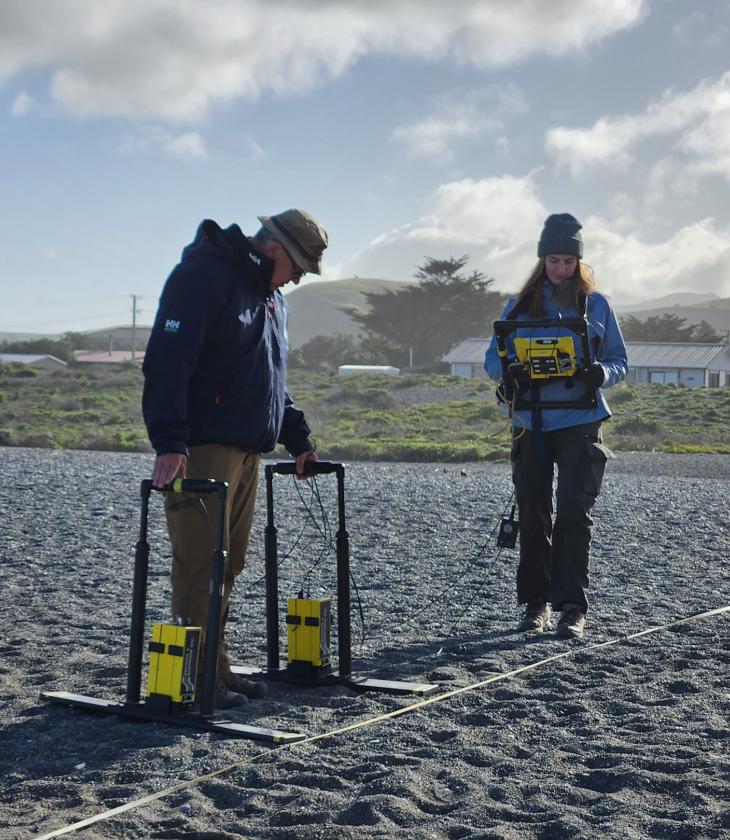 Harry Jol and female student taking ground radar reading by the ocean 