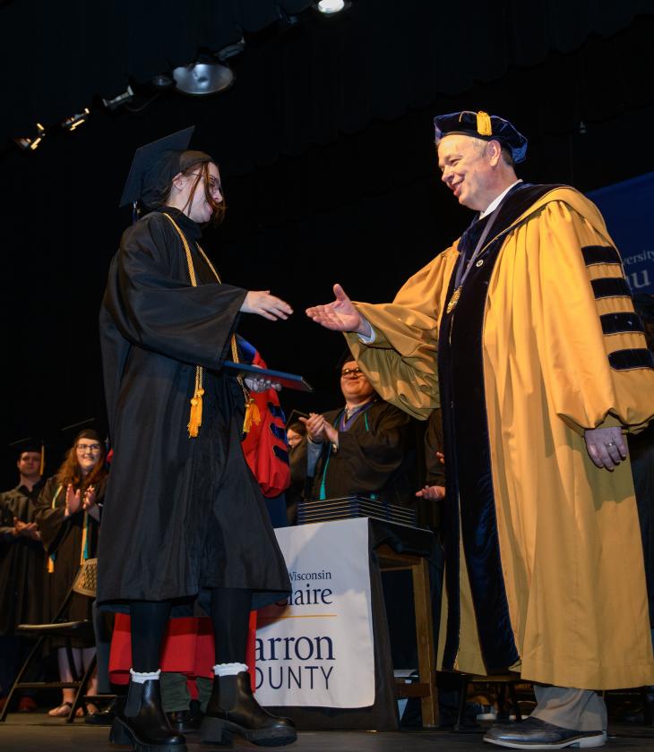 Chancellor Schmidt shaking graduate hand, Barron campus 