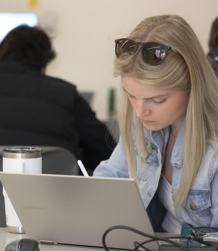 student at a laptop in a classroom 