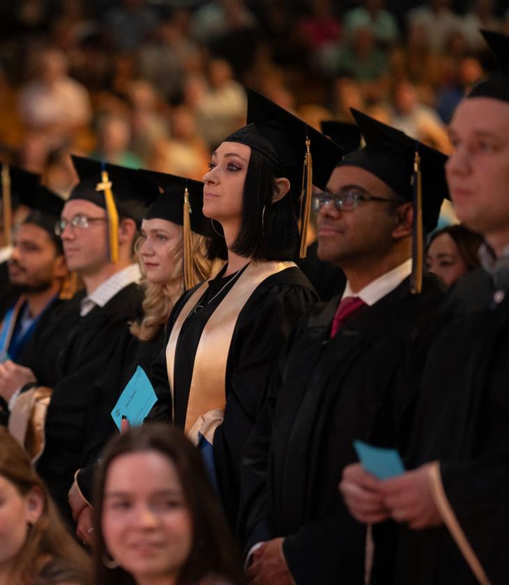 Graduates stand ready to receive their diploma 