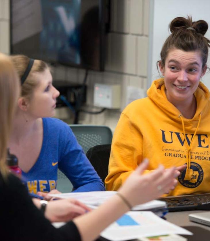 students in CSD lab, one in program gold sweatshirt 