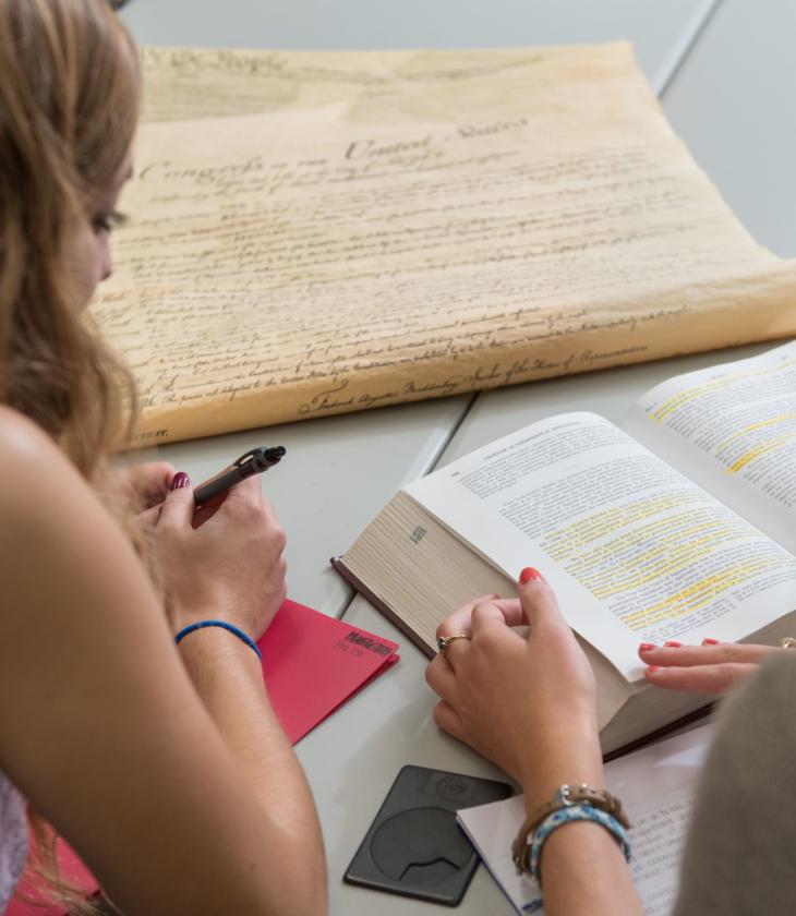 Two students discuss the Bill of Rights and U.S. Constitution in the Hibbard Hall Political Science study area