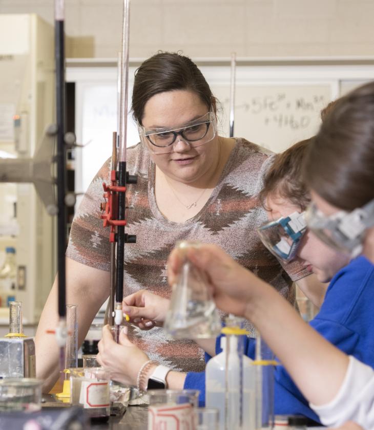 Students work on a chemistry experiment in a lab on campus.