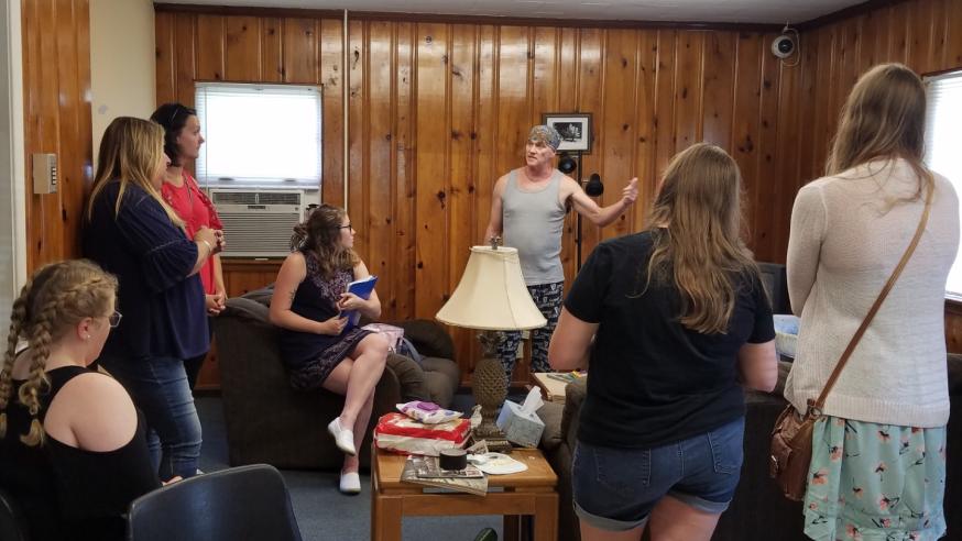 Students in a staged home learn about child welfare.