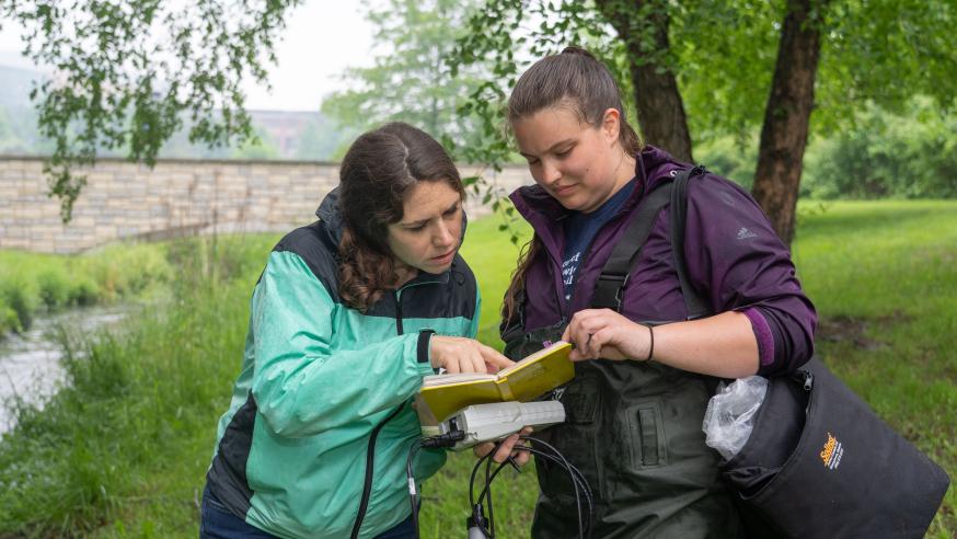 Student and instructor next to Niagara Creek collecting water samples