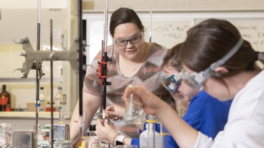 Students work on a chemistry experiment in a lab on campus.