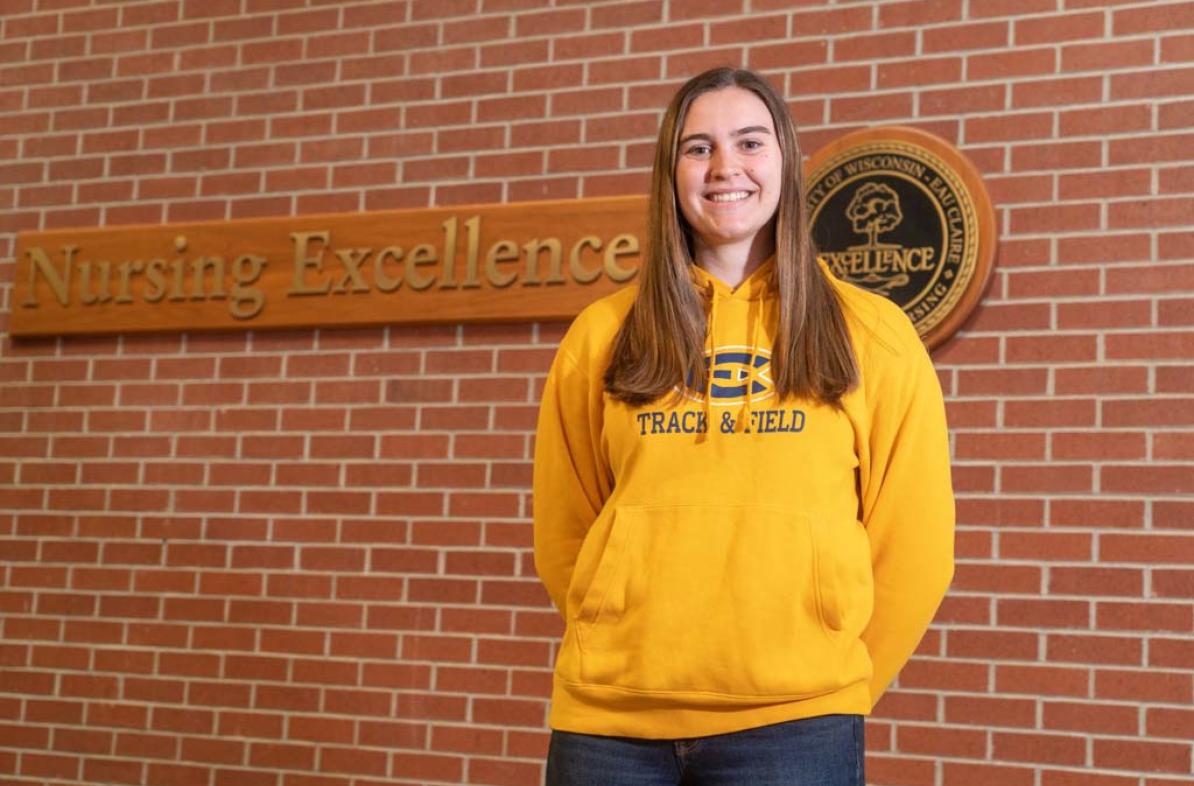 Teagan Jones in a gold Atheltics sweatshirt, smiling 