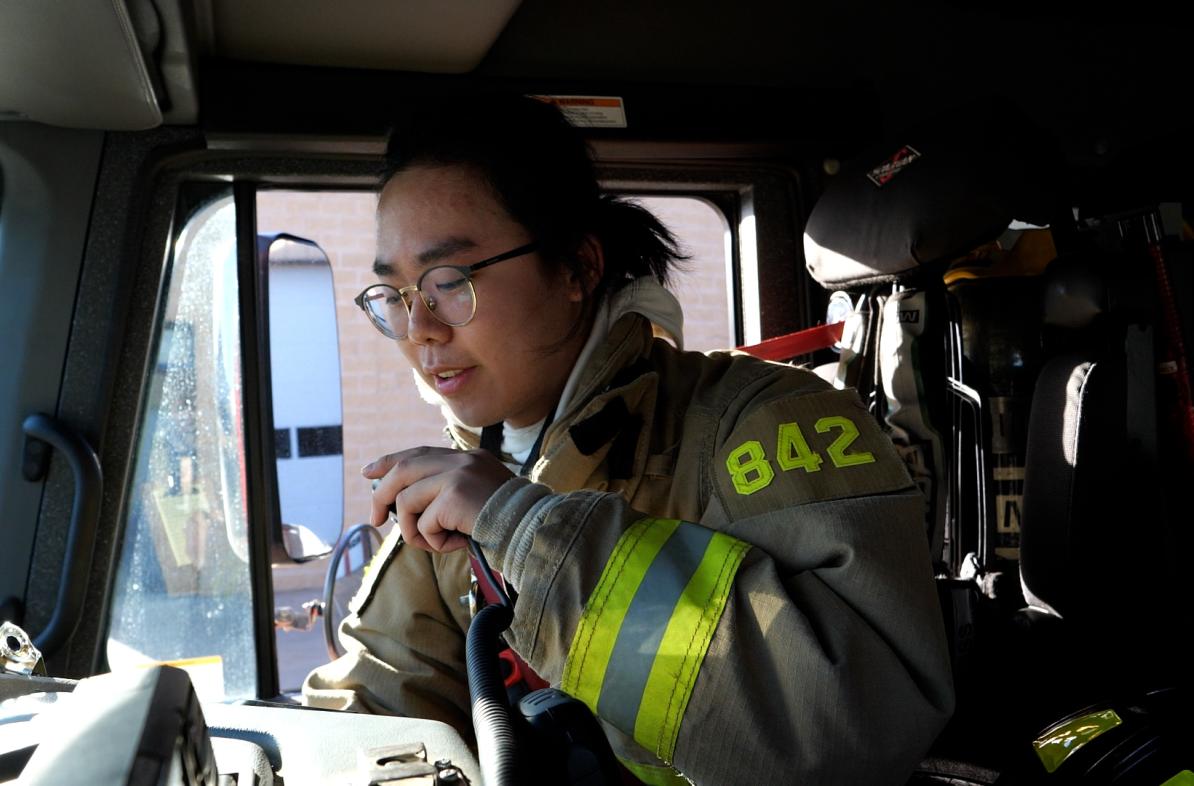 Student firefighter in gear in firetruck 