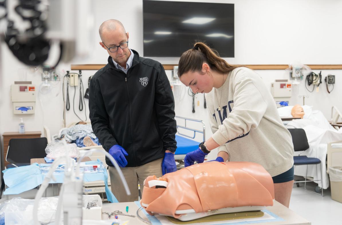 A student works on a simulation with a Mayo Clinic physician in a medical facility.