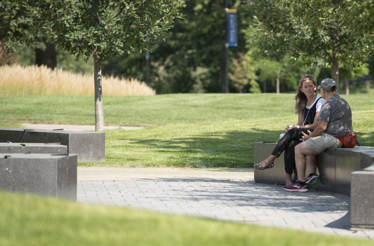 Faculty members sitting outside talking
