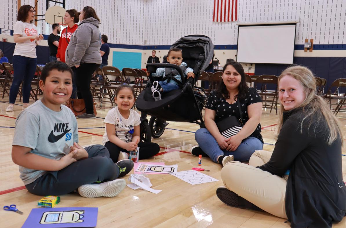 Blugold Halle Smith (right) works with an Eau Claire-area family on an art project during the first UW-Eau Claire campus-community Spanish Literacy Event.