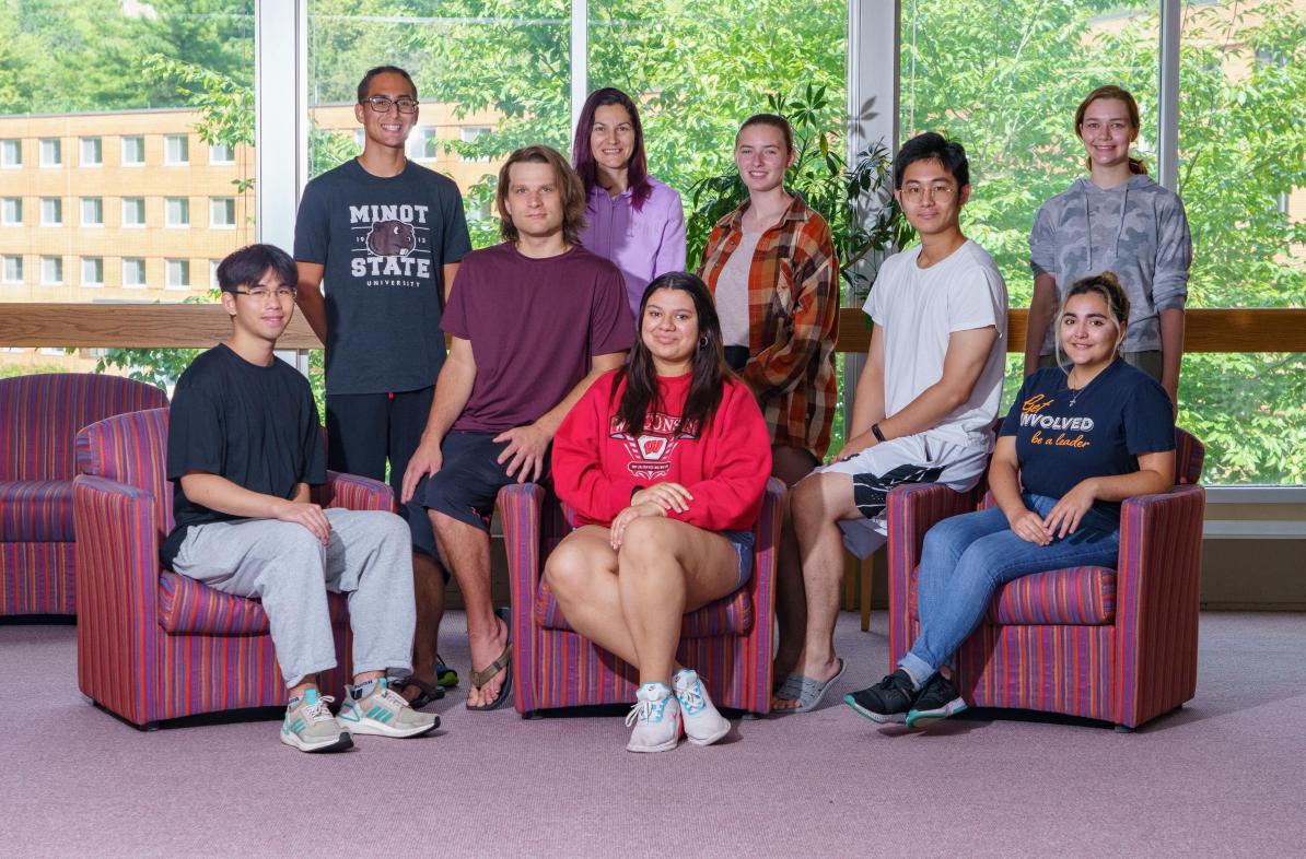 Group of students mixed genders, sitting and standing in library breezeway