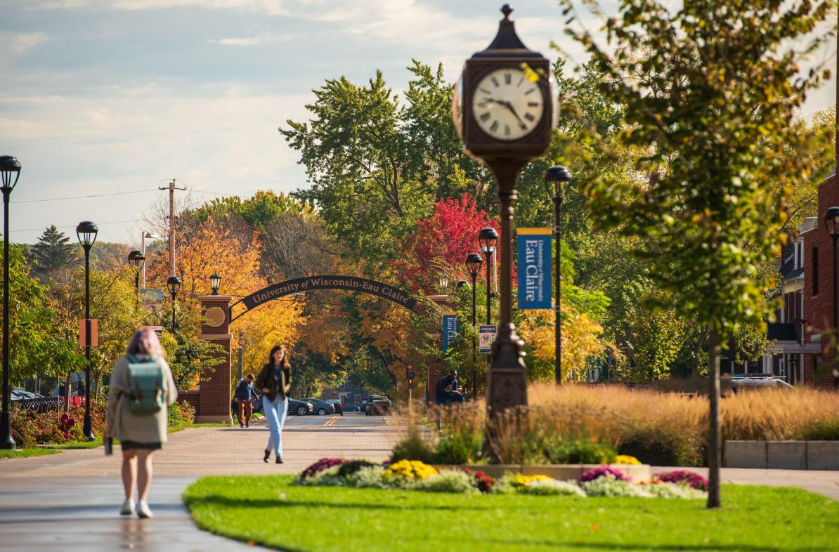 Students walk on Garfield Ave with UW Eau Claire arch in background.