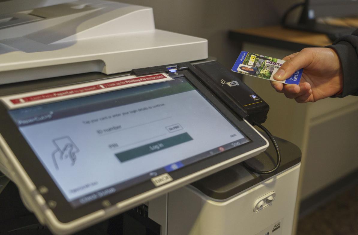 student using ID card to print