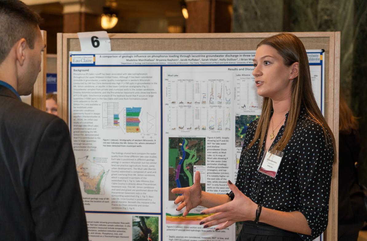 female student describing her research to listener in the Research in the Rotunda event