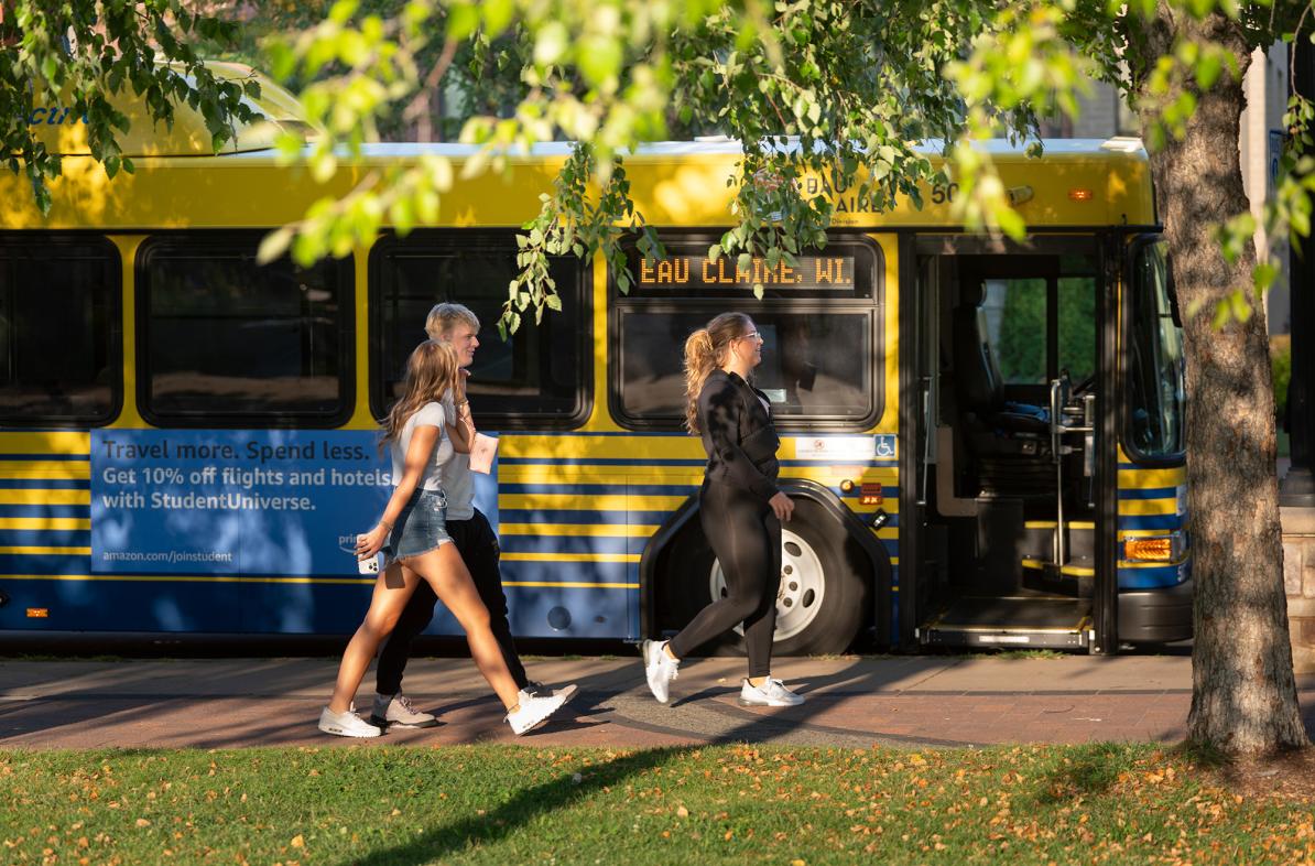 Students walking to enter the city bus on campus