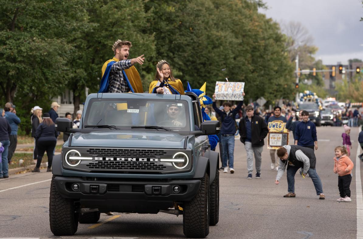 Homecoming royalty in a Bronco during 2023 Homecoming parade for UWEC