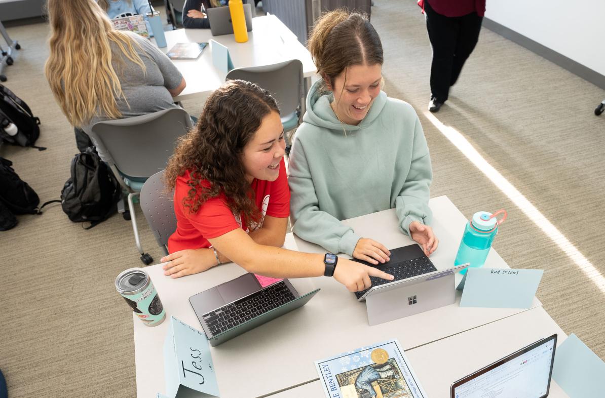 overhead view of two students at a desk station sharing an iPad