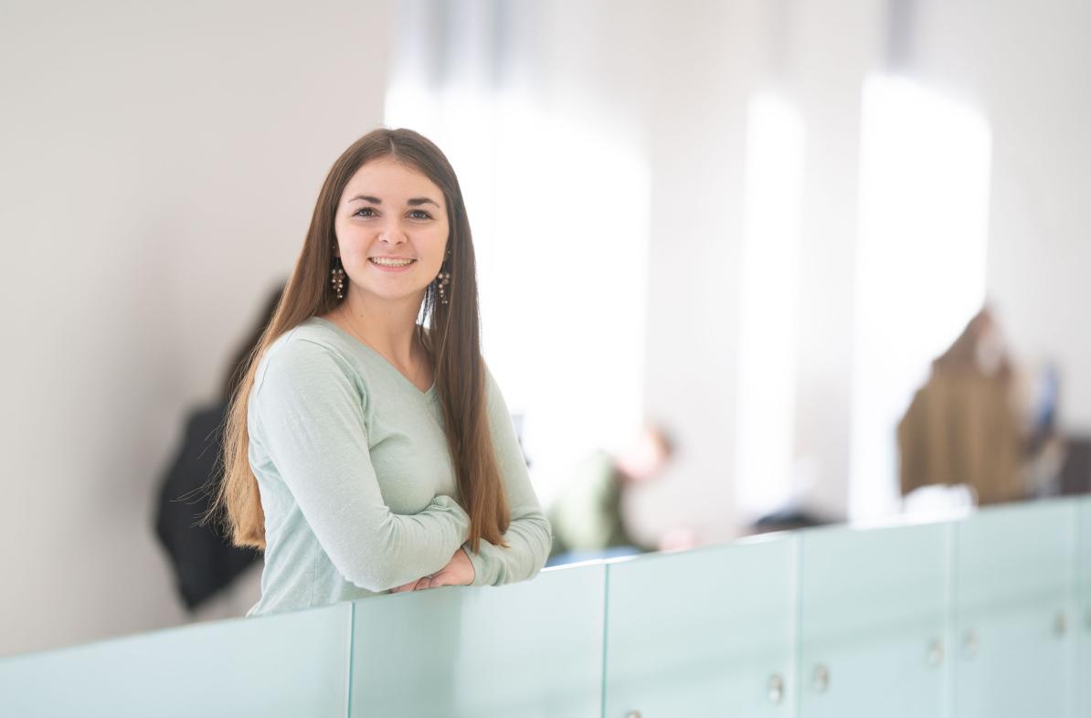 Annie Fochs in second floor of Centennial Hall, leaning on glass half wall.