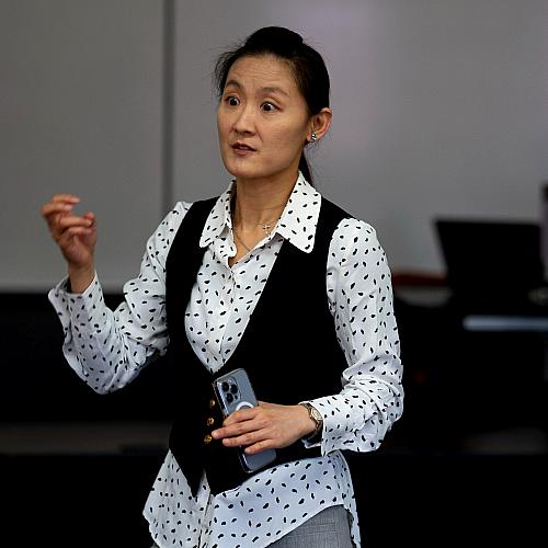 faculty standing in front of a class, using hand gestures